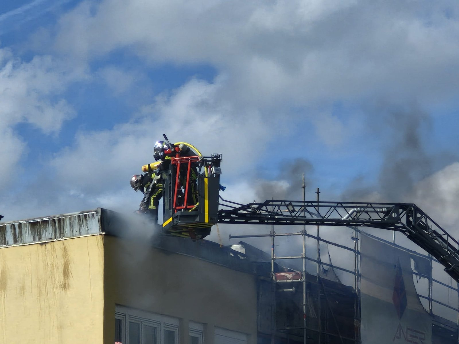 Nacelle avec pompiers au-dessus du toit en feu